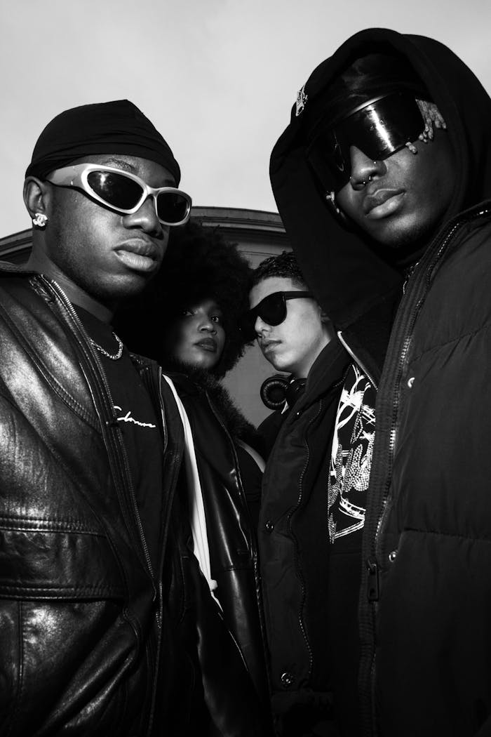 Trendy group of four adults posing in urban attire, highlighting afro-centric fashion.